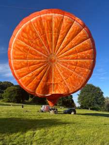 Orange hot air balloon G-CDXW, a Cameron ORANGE-120 (fruit, food)