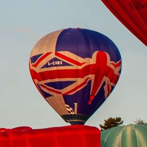 Flag hot air balloon G-CHBX, a Lindstrand HOT AIR Balloons LBL 77A (gb, uk), seen at Leigh Woods, North Somerset, United Kingdom on 8 August 2014. Photograph by Dave
